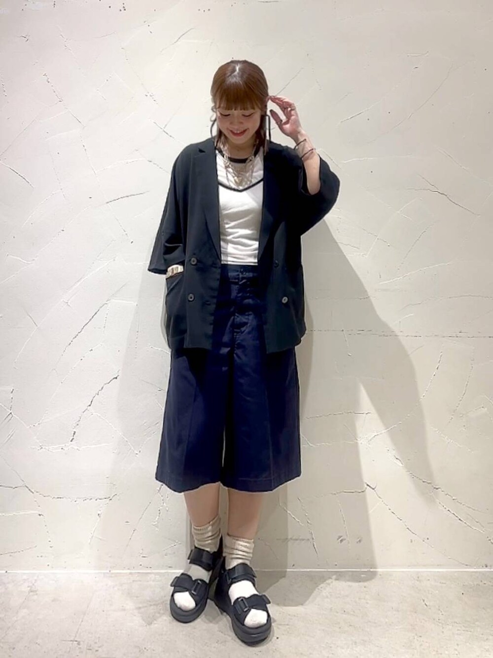 ホワイト系のTシャツ/カットソー、ブルー系のその他パンツ、ブラック系のサンダルを着用したレディースの春コーディネートの3枚目の写真