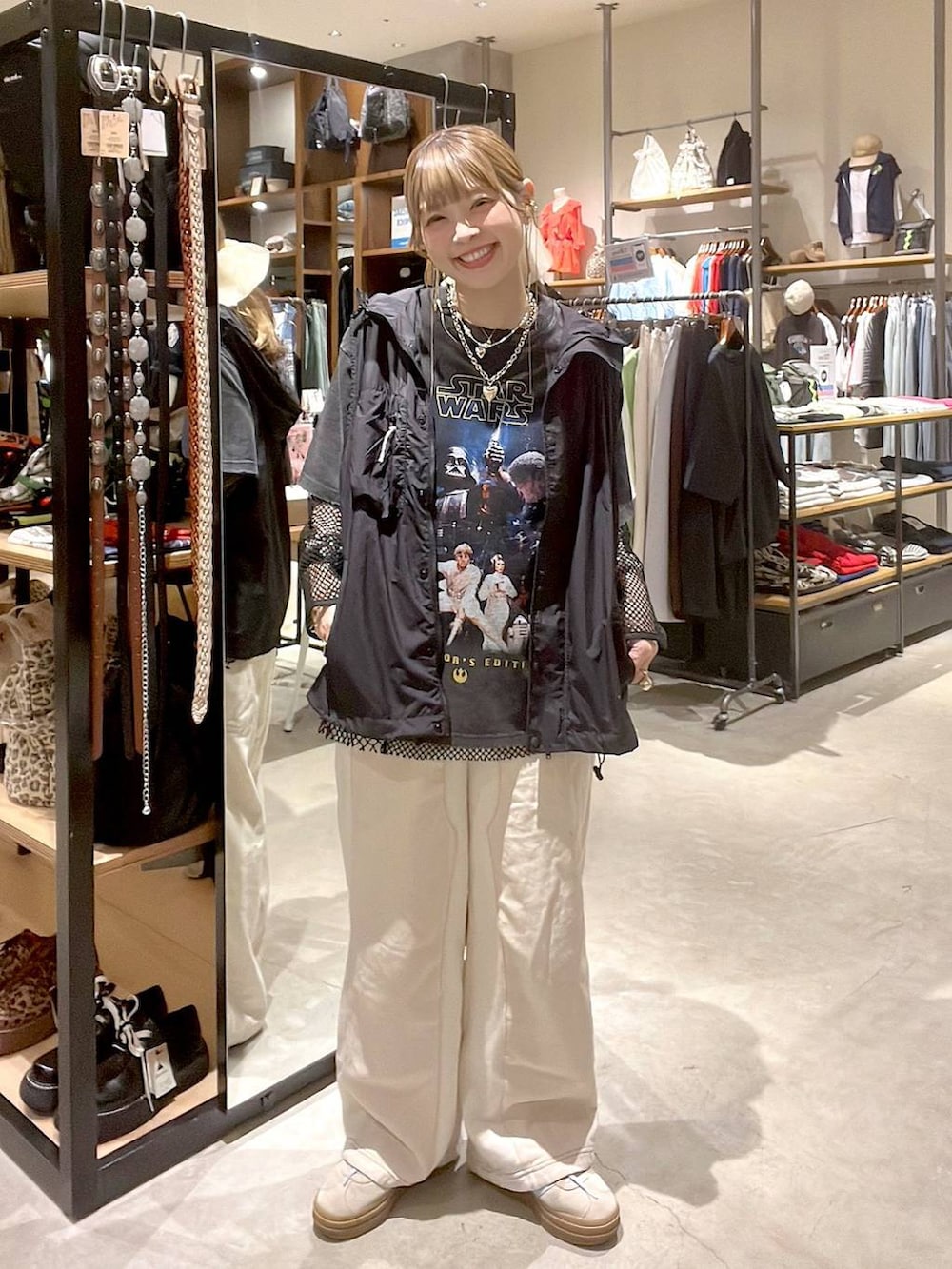 ベージュ系のデニムパンツ、ブラック系のベスト、ブラック系のTシャツ/カットソーを着用したレディースの春コーディネートの9枚目の写真