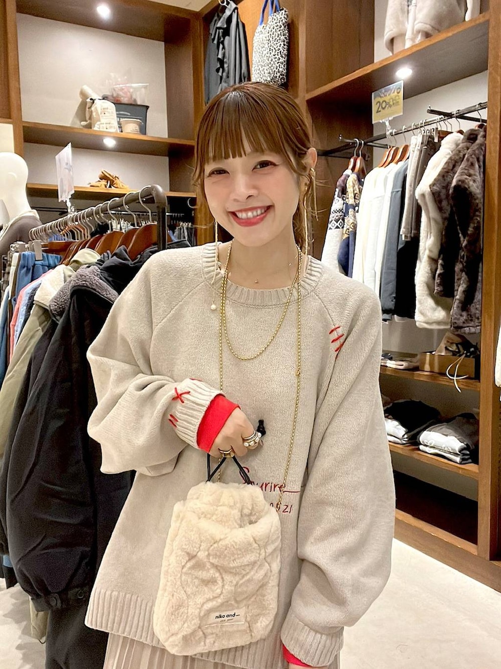 ベージュ系のスカート、ベージュ系のショルダーバッグ、イエロー系のネックレスを着用したレディースの秋コーディネートの5枚目の写真