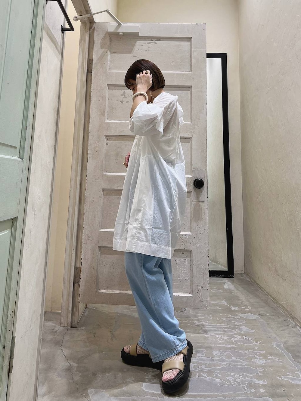 イエロー系のサンダル、ブルー系のその他パンツ、ホワイト系のチュニックを着用したレディースの春コーディネートの3枚目の写真