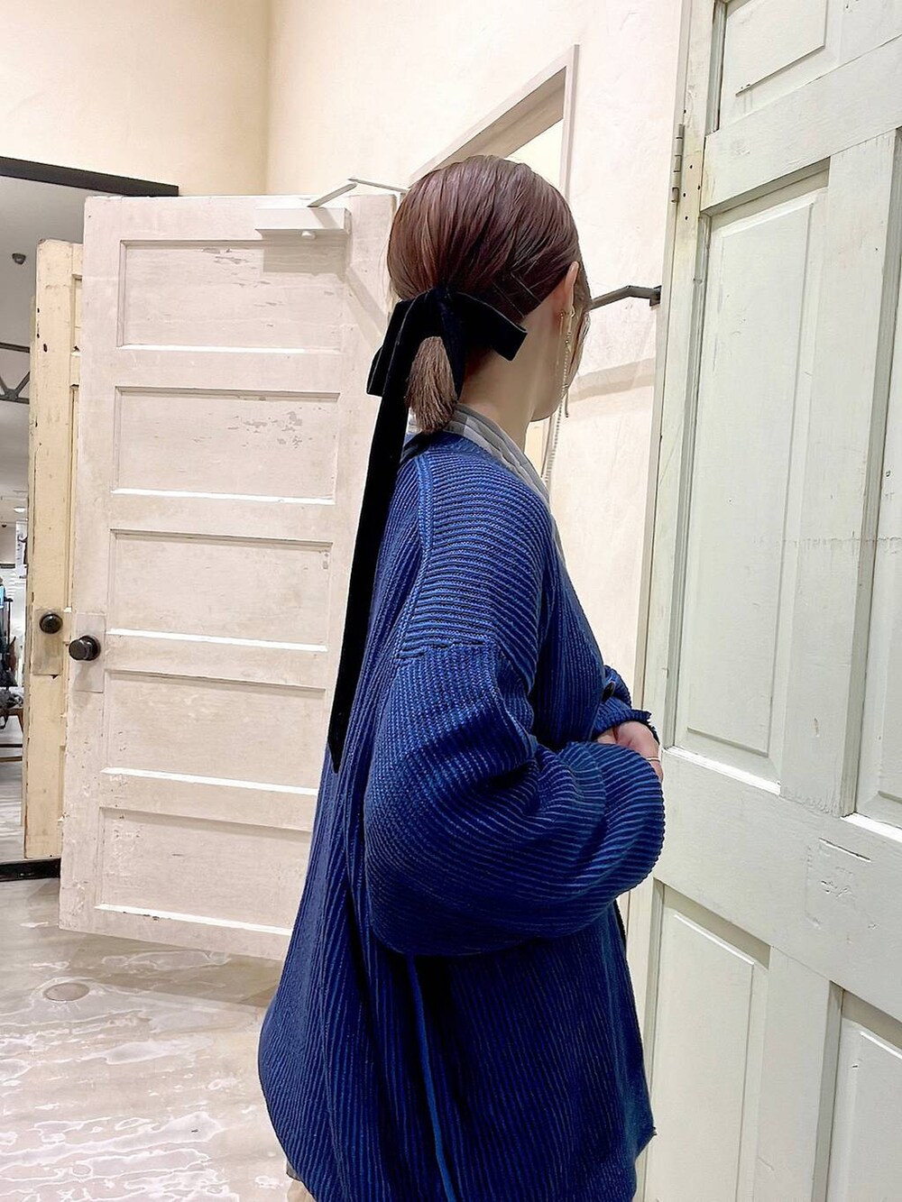 グレー系のシャツ/ブラウス、ベージュ系のスカート、ブルー系のカーディガン/ボレロを着用したレディースの秋コーディネートの5枚目の写真