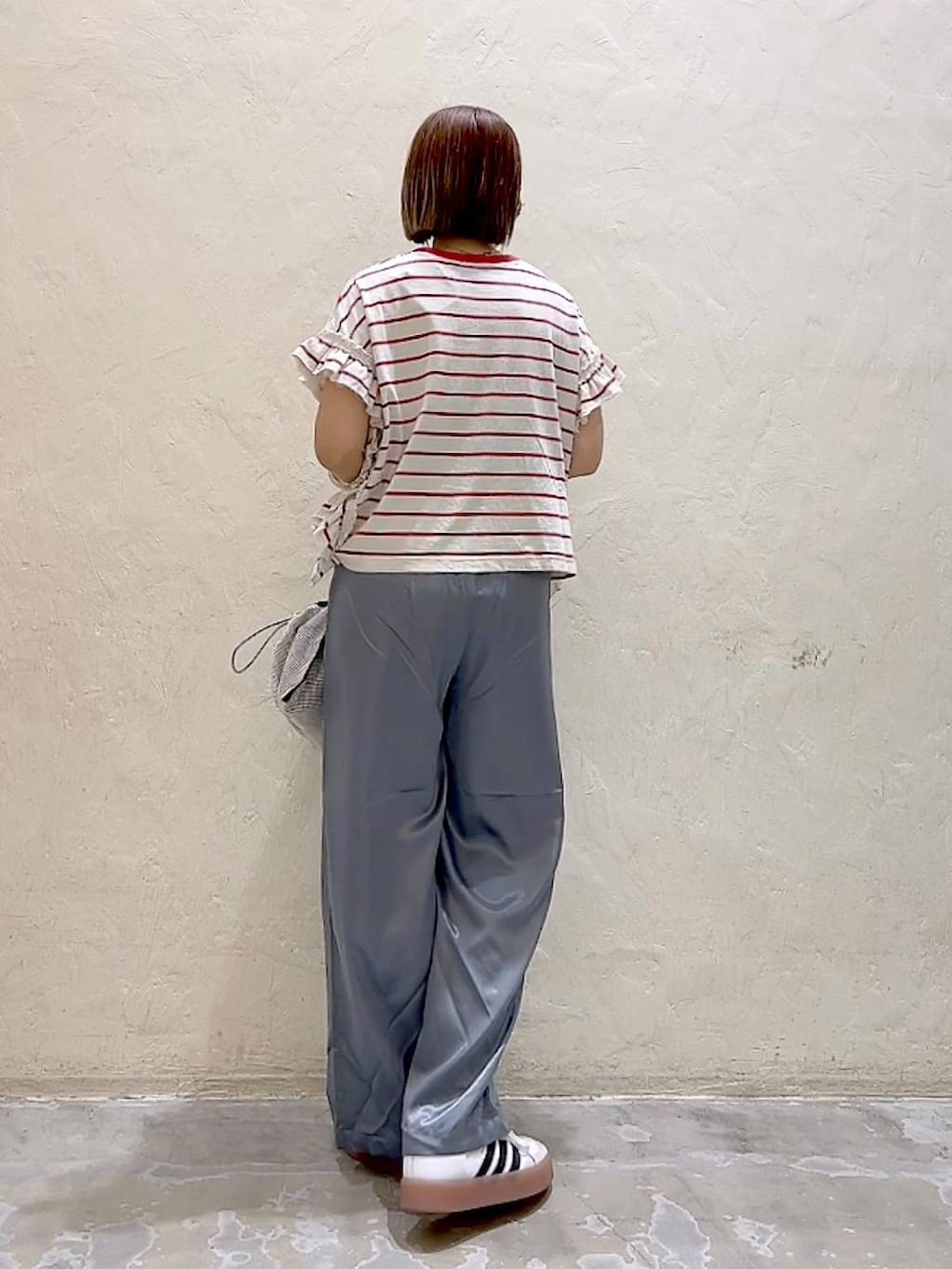 レッド系のTシャツ/カットソー、グレー系のショルダーバッグ、グレー系のその他パンツを着用したレディースの夏コーディネートの4枚目の写真