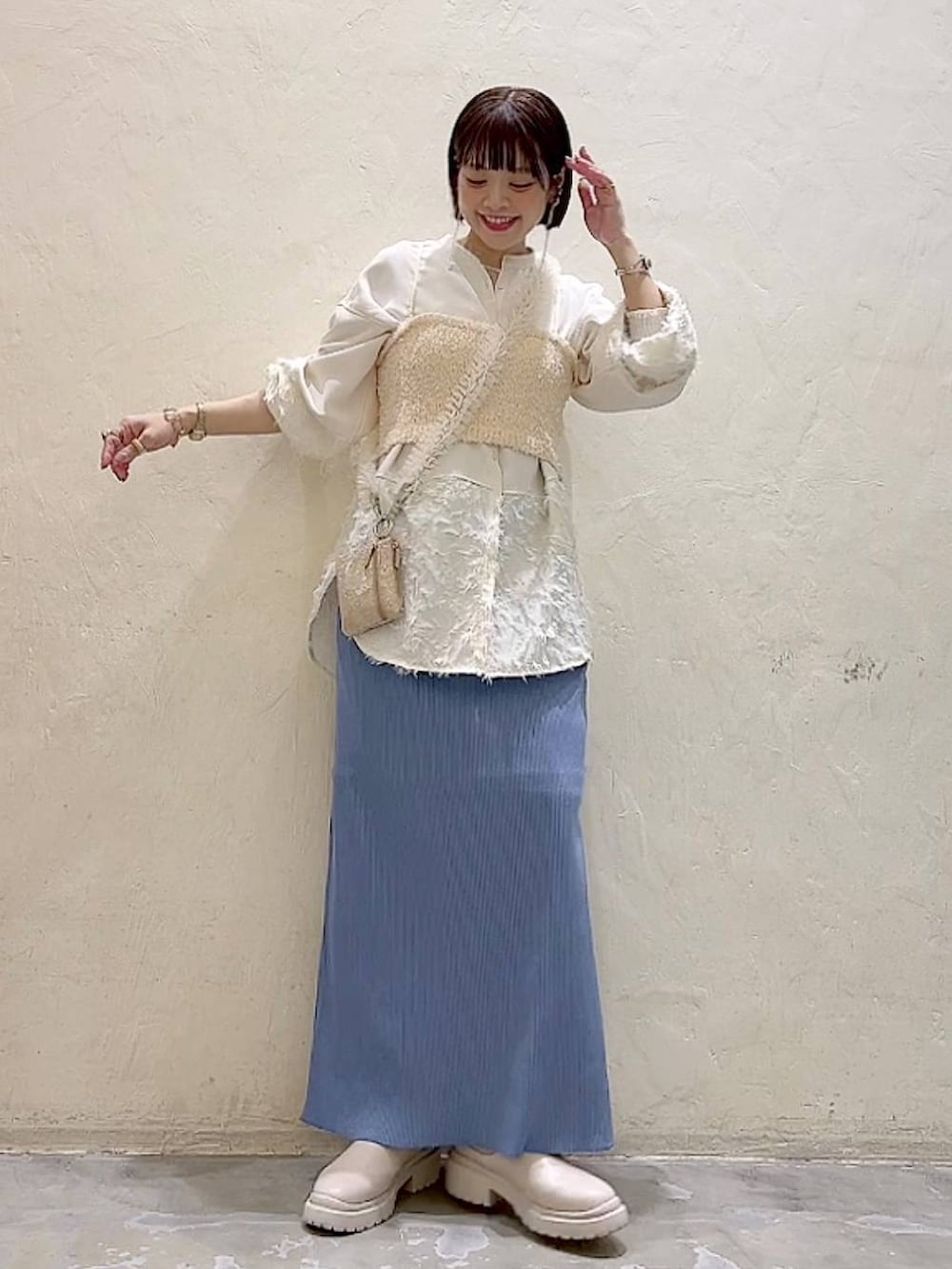 ベージュ系のシャツ/ブラウス、ベージュ系のベスト、ベージュ系のブーツを着用したレディースの冬コーディネートの2枚目の写真