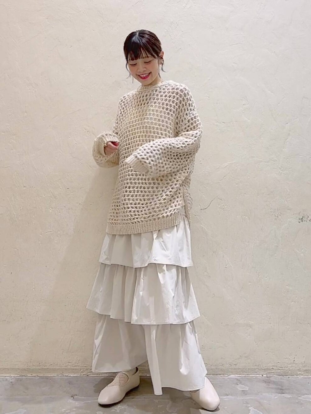 ホワイト系のパンプス、ベージュ系のニット/セーター、ベージュ系のスカートを着用したレディースの冬コーディネートの2枚目の写真