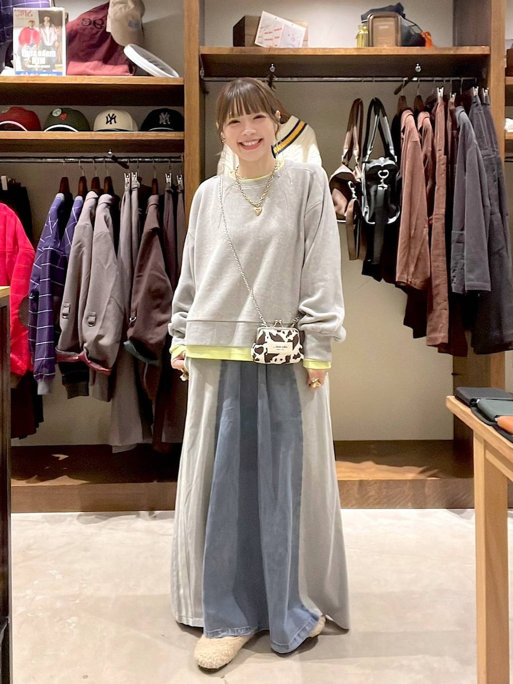 ベージュ系のパンプス、グレー系のスウェット、ブルー系のデニムスカートを着用したレディースの秋コーディネートの6枚目の写真
