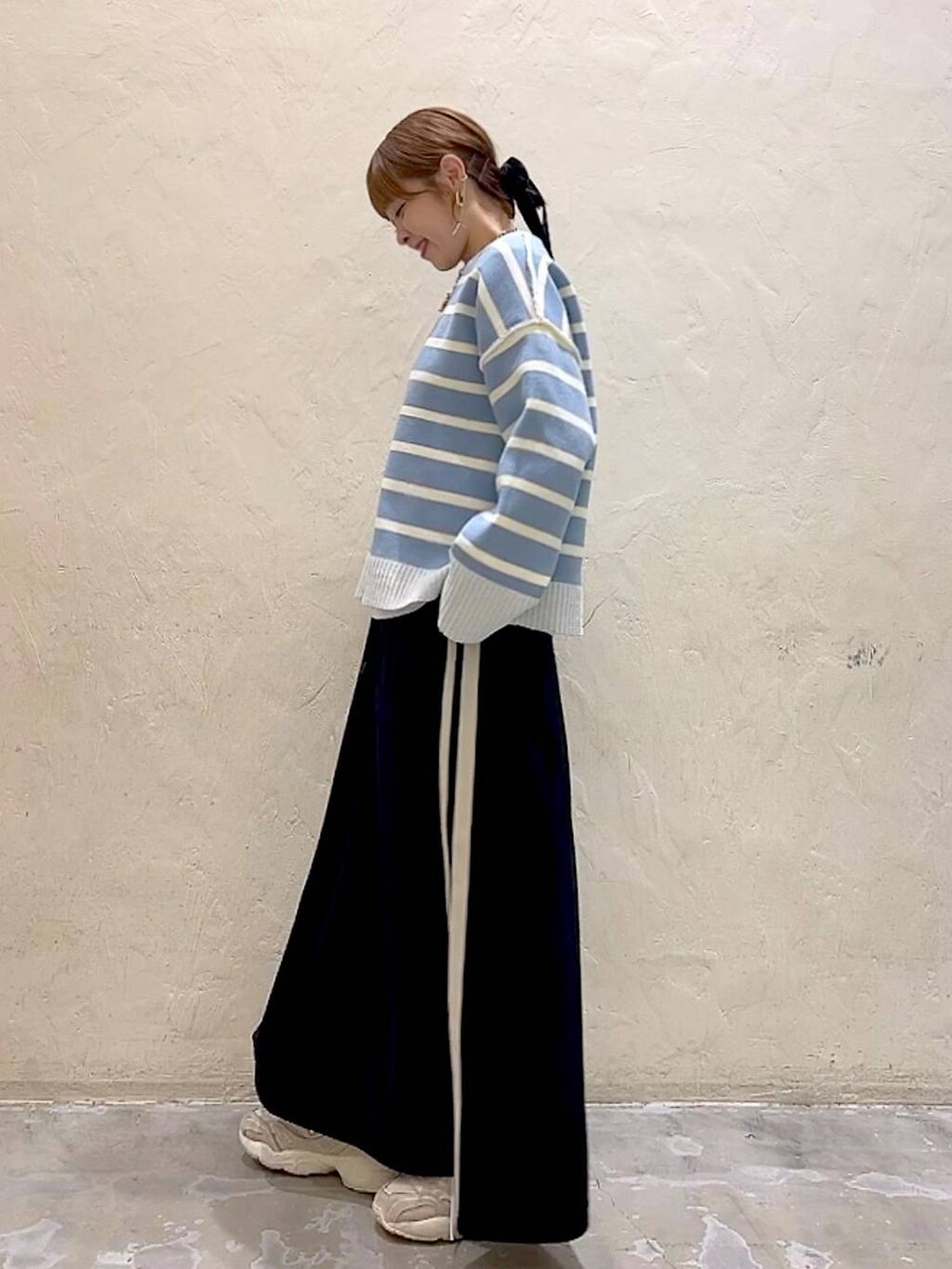 ホワイト系のTシャツ/カットソー、ブラック系のスカート、ベージュ系のニット/セーターを着用したレディースの冬コーディネートの6枚目の写真