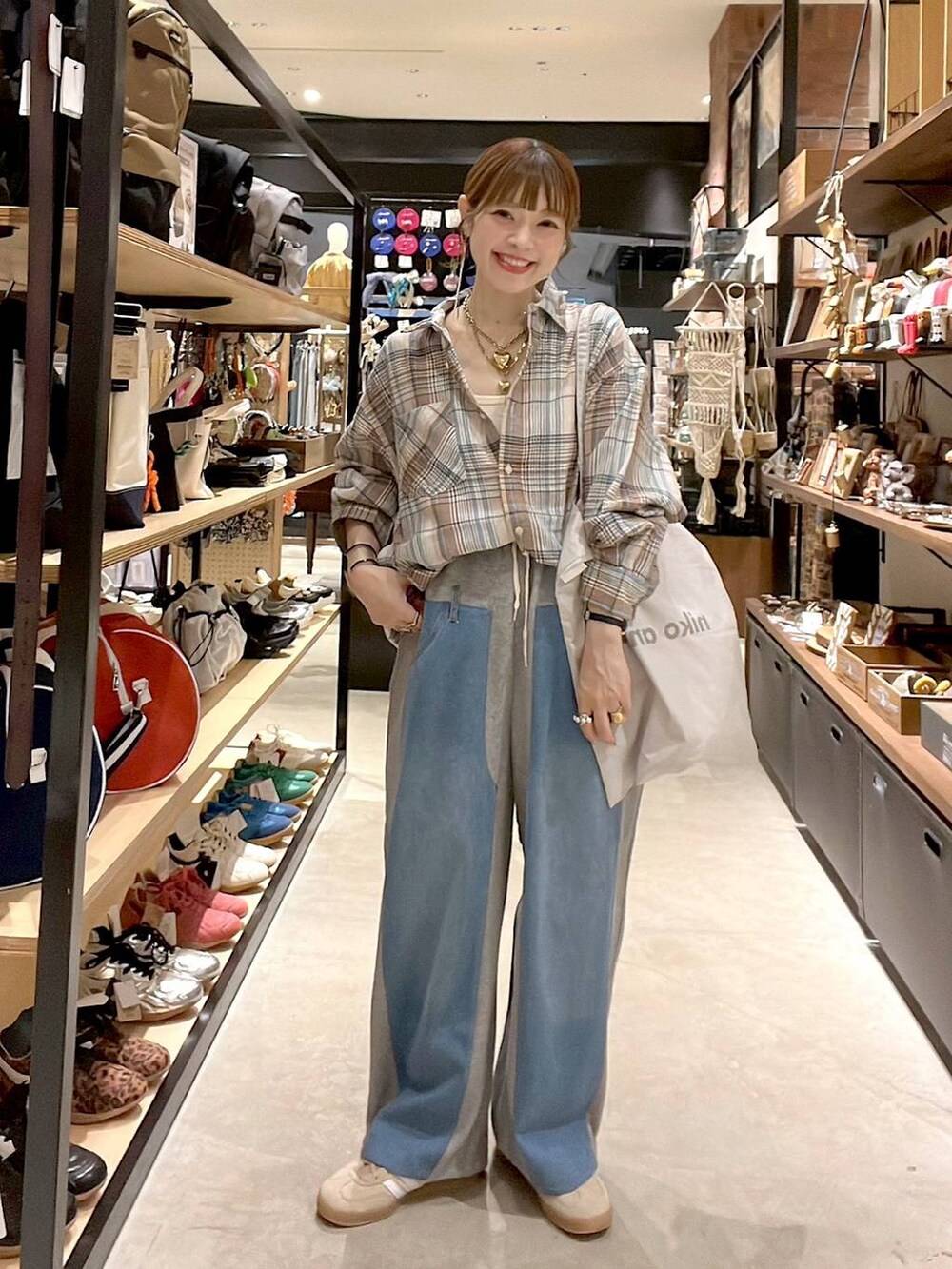 ベージュ系のシャツ/ブラウス、グレー系のトートバッグ、グレー系のデニムパンツを着用したレディースの夏コーディネートの3枚目の写真