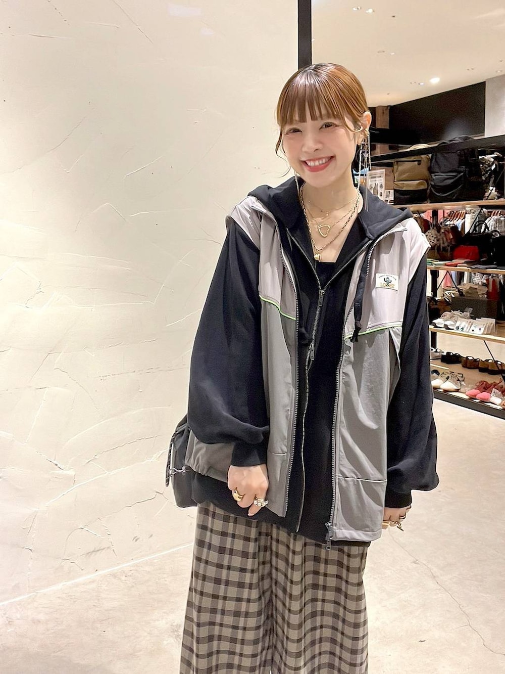 ブラック系のショルダーバッグ、ブラウン系のその他パンツ、イエロー系のネックレスを着用したレディースの秋コーディネートの7枚目の写真