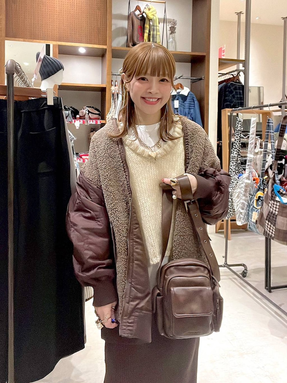 ホワイト系のTシャツ/カットソー、レッド系のMA-1、ブラウン系のスカートを着用したレディースの冬コーディネートの2枚目の写真