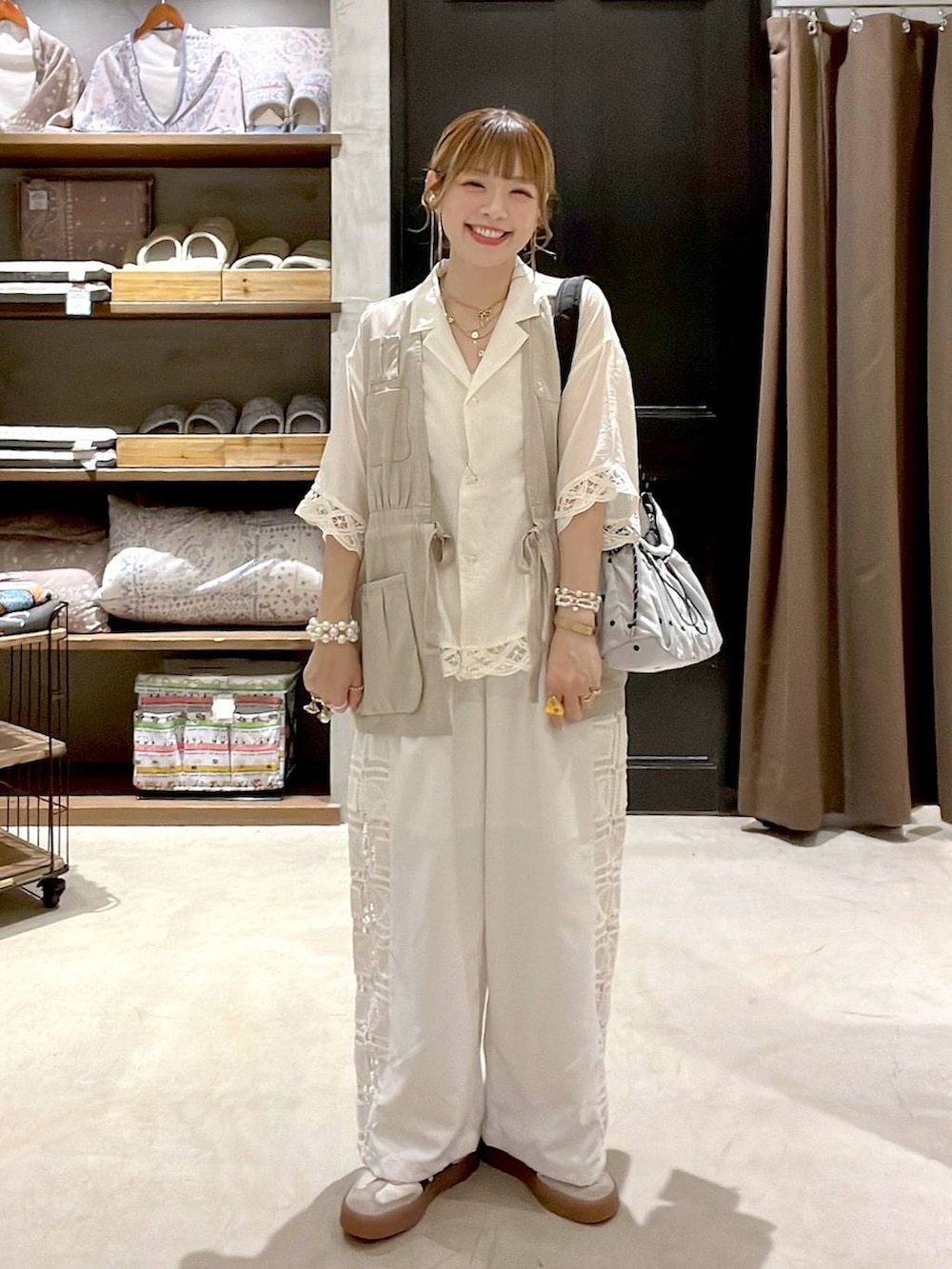 ベージュ系のベスト、ホワイト系のその他パンツ、その他のショルダーバッグを着用したレディースの夏コーディネートの6枚目の写真