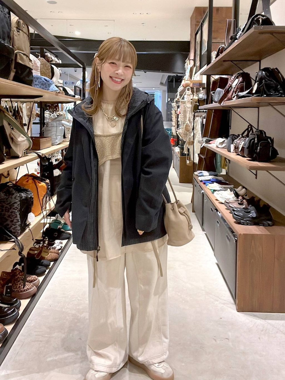 ベージュ系のデニムパンツ、ベージュ系のショルダーバッグ、グレー系のその他アウターを着用したレディースの春コーディネートの2枚目の写真