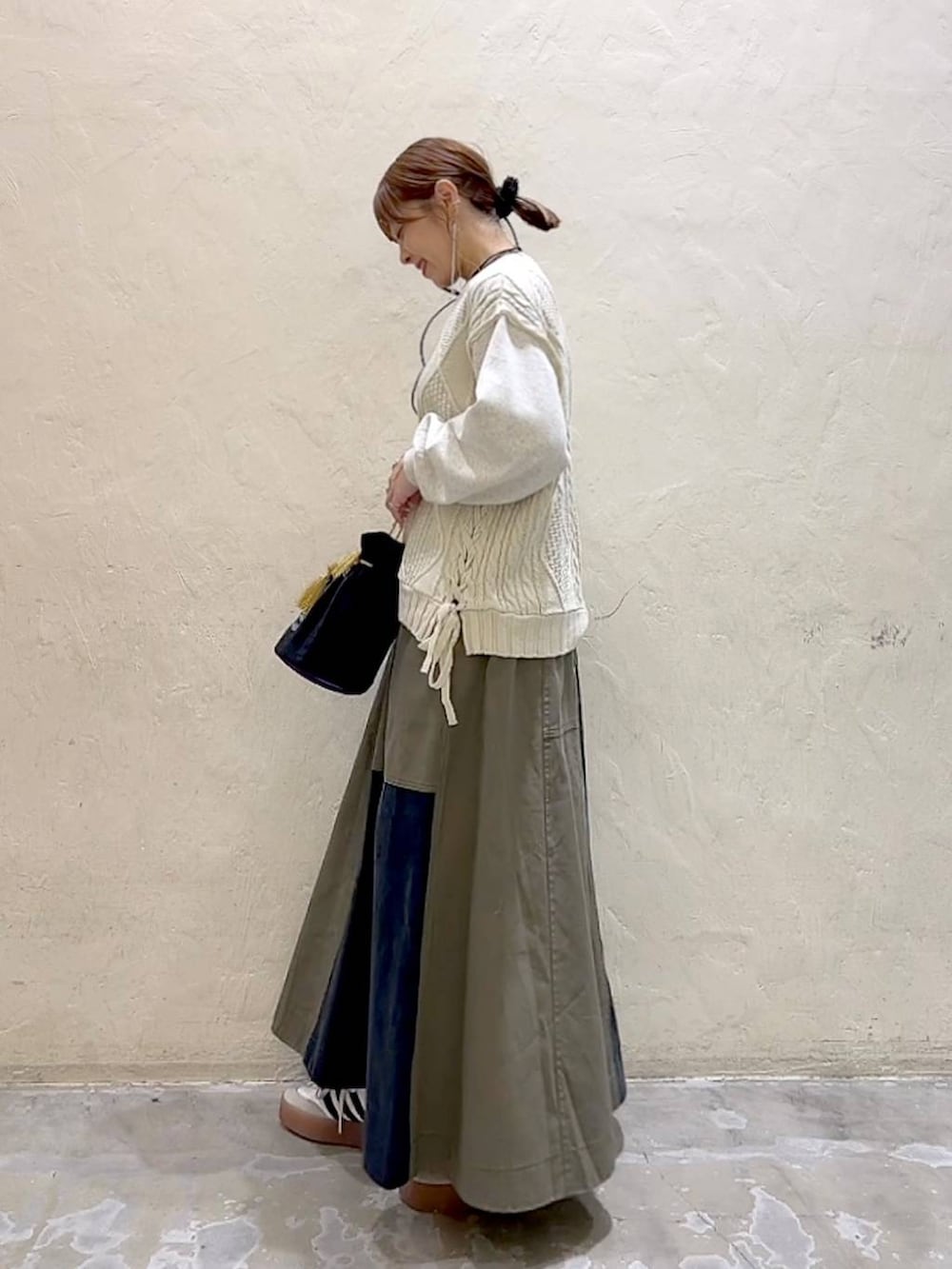 その他のショルダーバッグ、ベージュ系のニット/セーター、グリーン系のスカートを着用したレディースの冬コーディネートの6枚目の写真