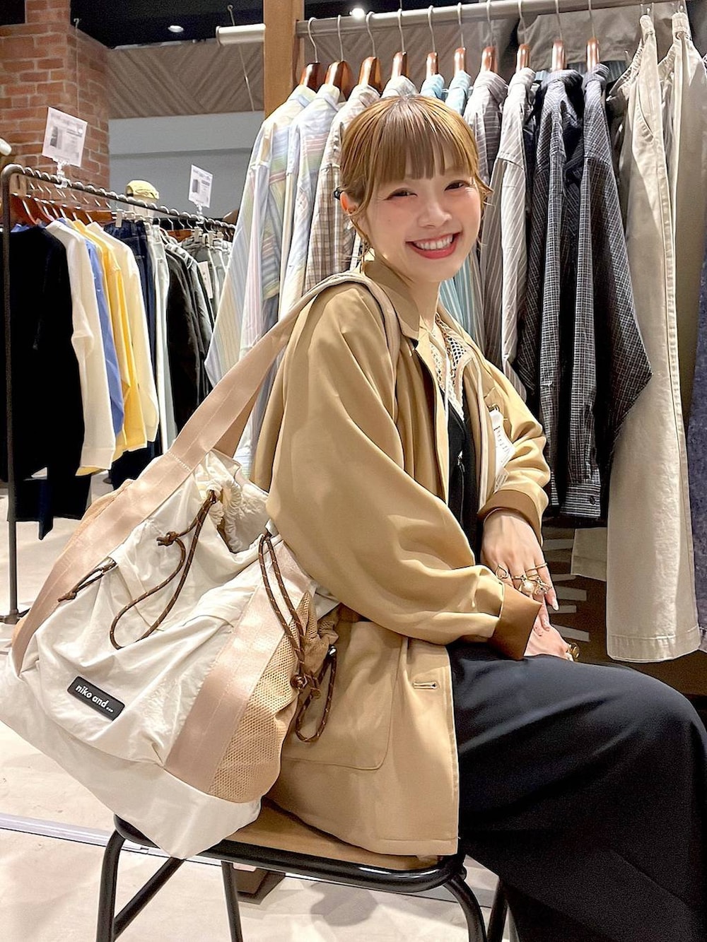 ベージュ系のトートバッグ、ブラック系のサロペット/オーバーオール、ホワイト系のTシャツ/カットソーを着用したレディースの冬コーディネートの8枚目の写真