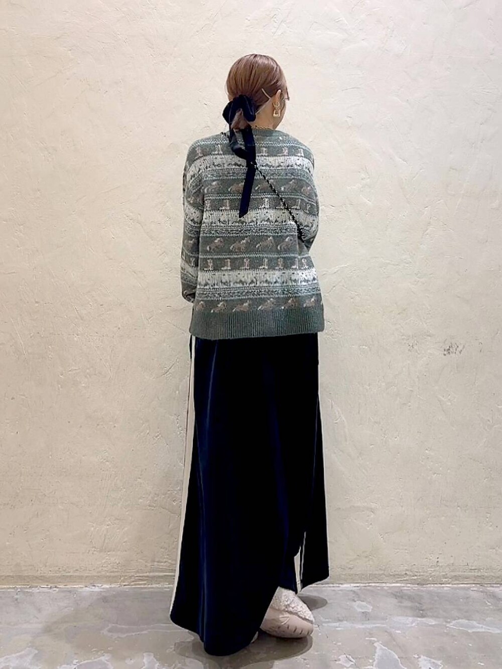 ブラック系のショルダーバッグ、ベージュ系のスリッポン、ブラック系のスカートを着用したレディースの冬コーディネートの6枚目の写真