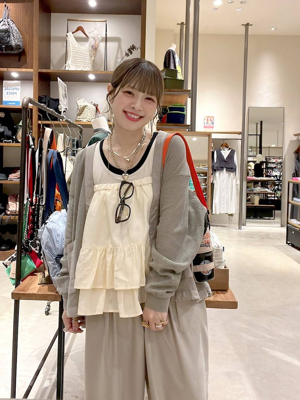 ホワイト系のタンクトップ、ベージュ系のスカート、ピンク系のネックレスを着用したレディースの春コーディネートの7枚目の写真