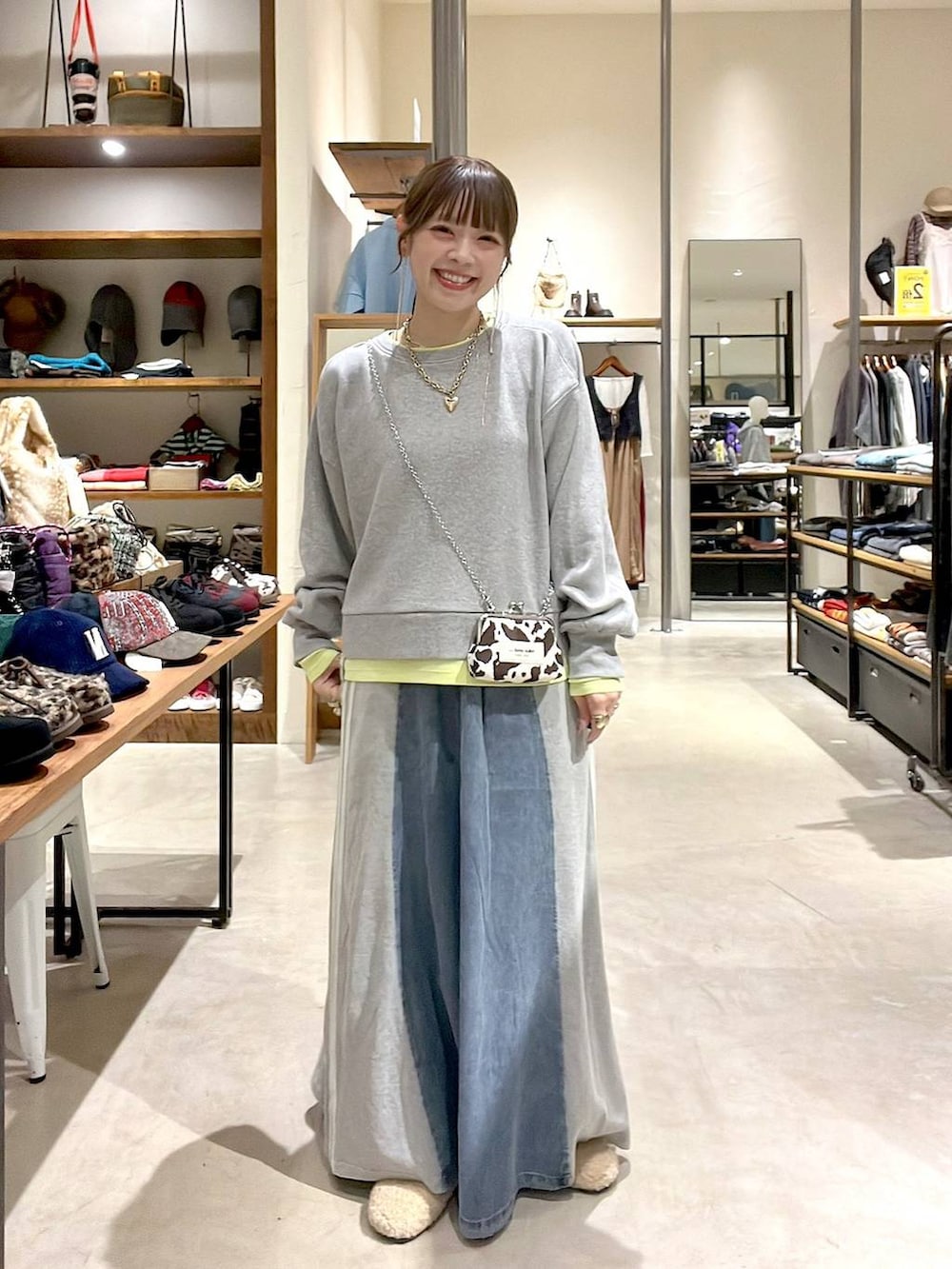 ベージュ系のパンプス、グレー系のスウェット、ブルー系のデニムスカートを着用したレディースの秋コーディネートの9枚目の写真