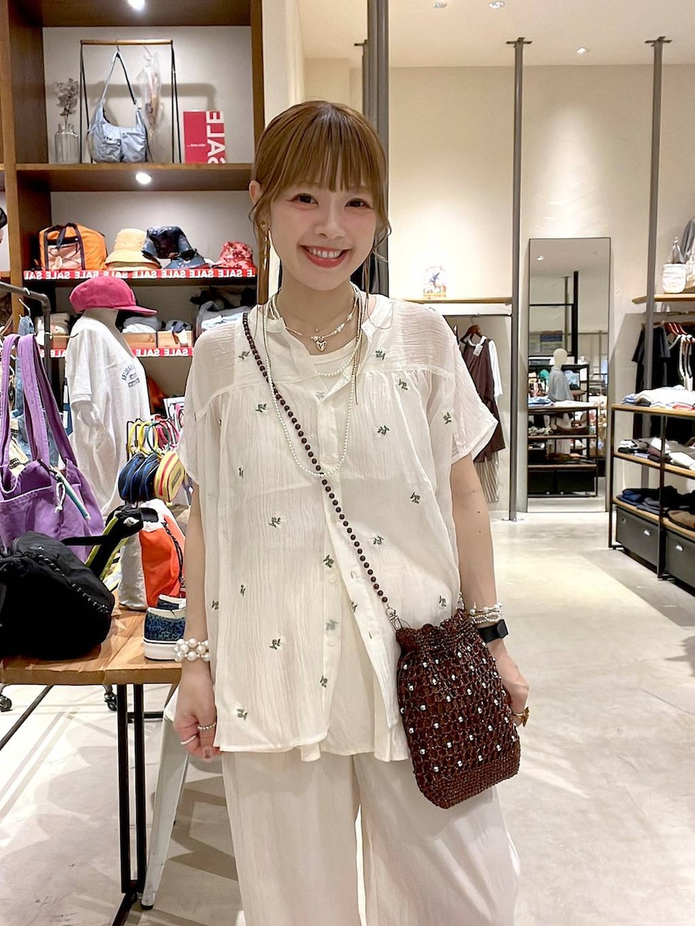 ブラウン系のショルダーバッグ、ホワイト系のシャツ/ブラウスを着用したレディースの夏コーディネートの7枚目の写真