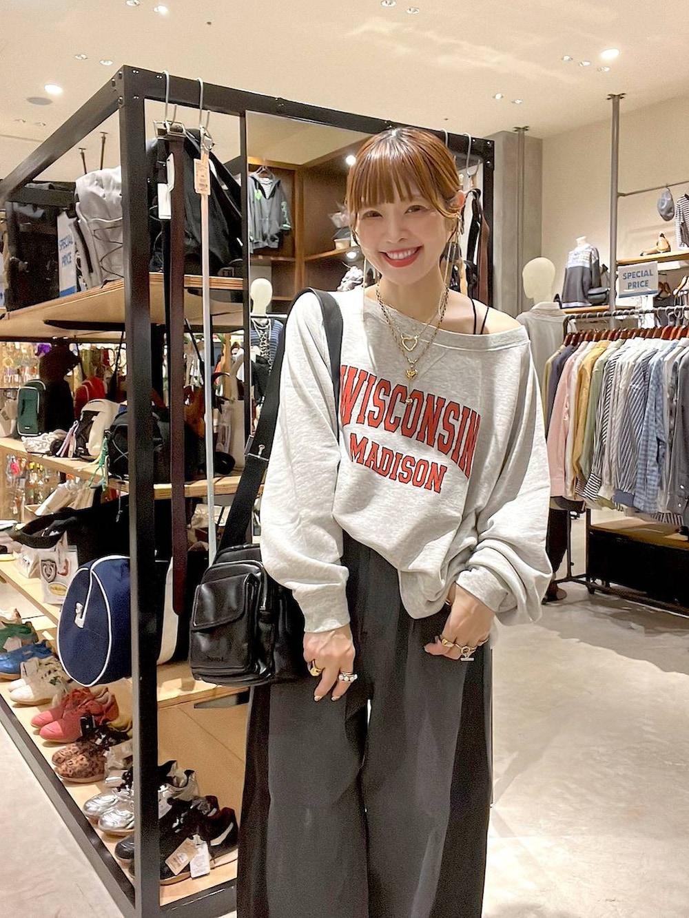 ベージュ系のスウェット、ブラック系のショルダーバッグ、イエロー系のネックレスを着用したレディースの秋コーディネートの3枚目の写真