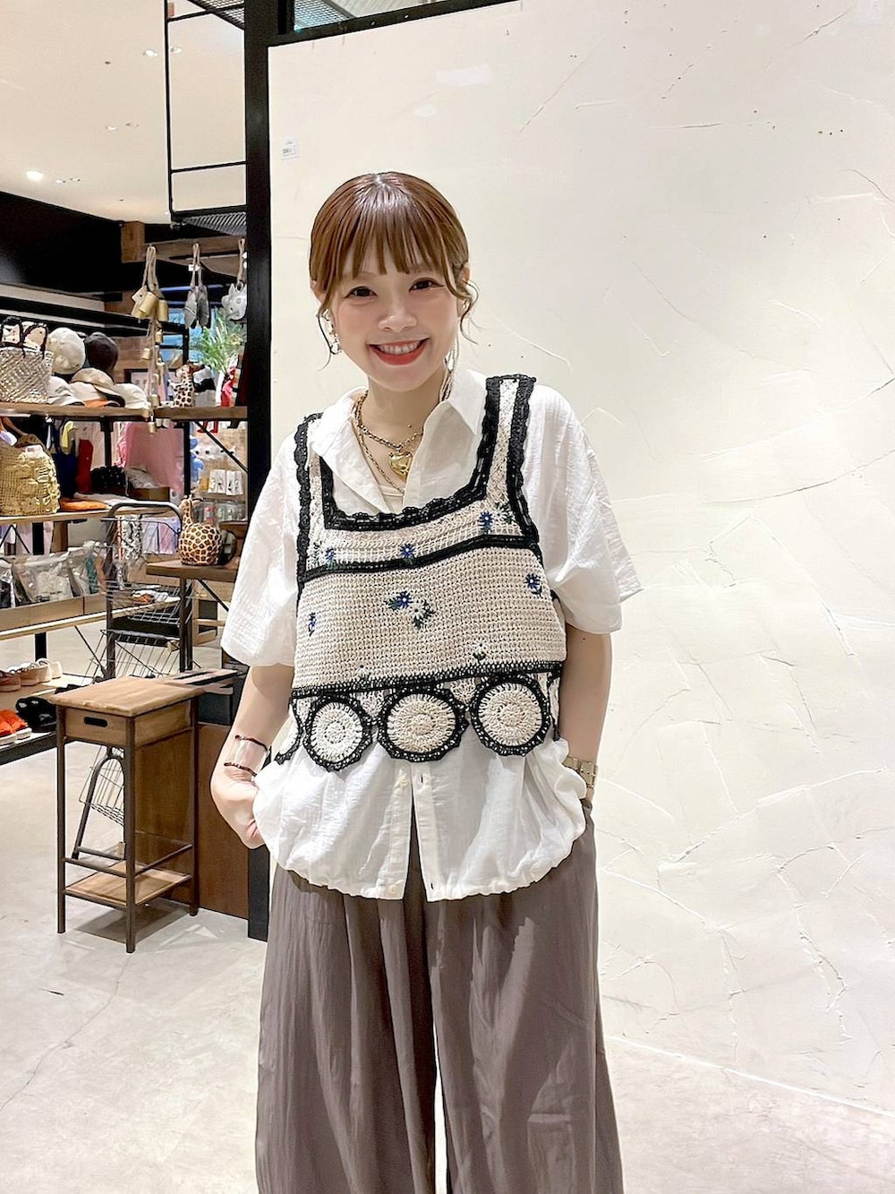 イエロー系のトートバッグ、ホワイト系のキャミソール、ホワイト系のシャツ/ブラウスを着用したレディースの夏コーディネートの2枚目の写真