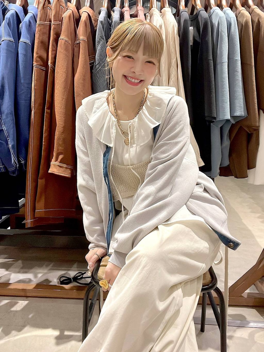 ホワイト系のシャツ/ブラウス、グレー系のカーディガン/ボレロを着用したレディースの春コーディネートの2枚目の写真