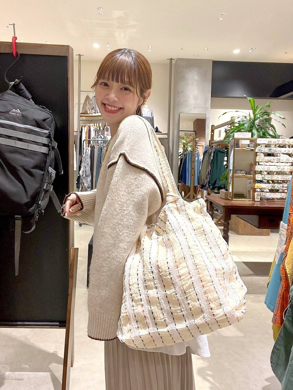 ベージュ系のスカート、その他のトートバッグ、ゴールド系のネックレスを着用したレディースの秋コーディネートの6枚目の写真