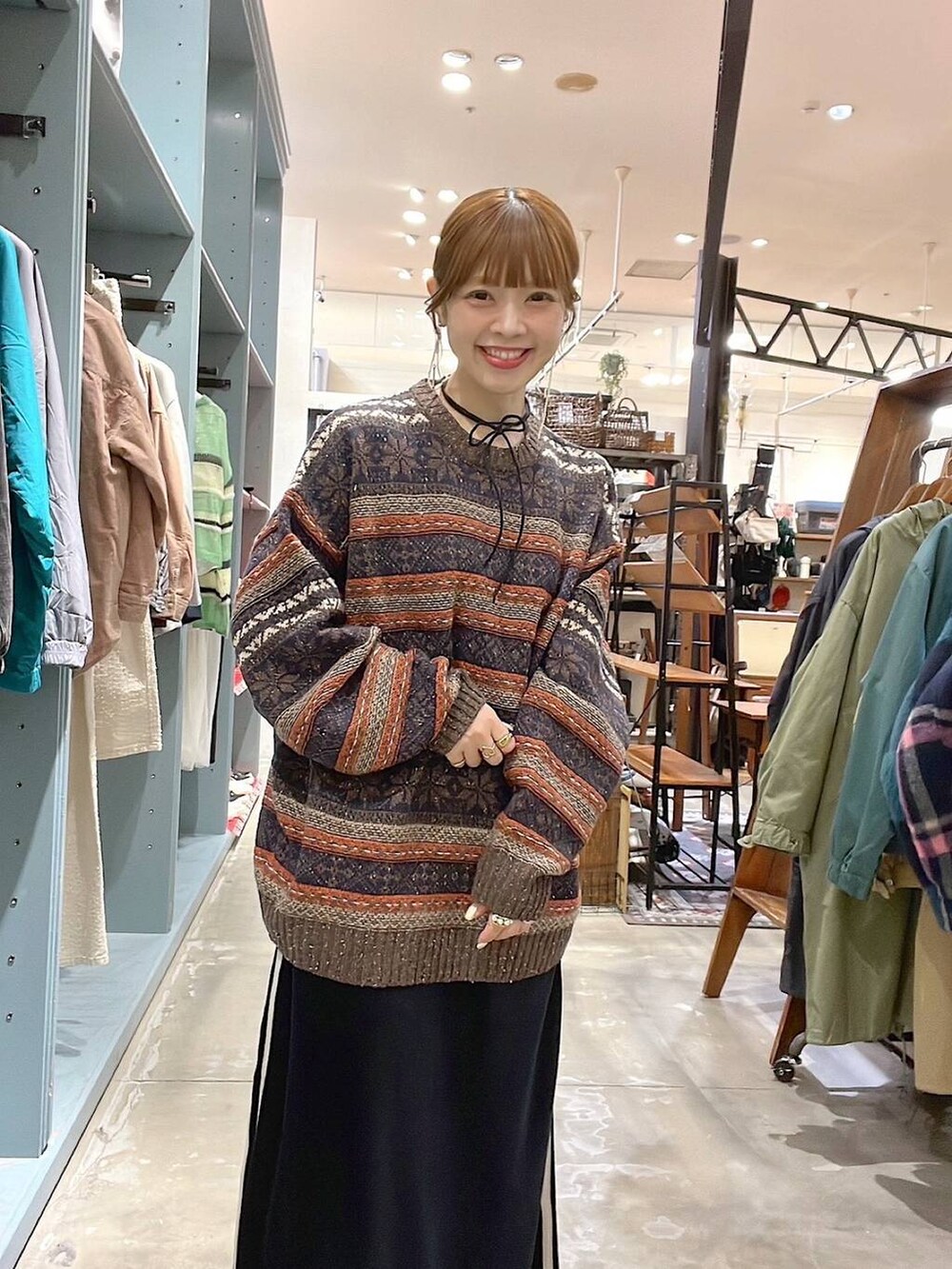 ブラック系のショルダーバッグ、ブラウン系のニット/セーター、ブラック系のスカートを着用したレディースの冬コーディネートの6枚目の写真