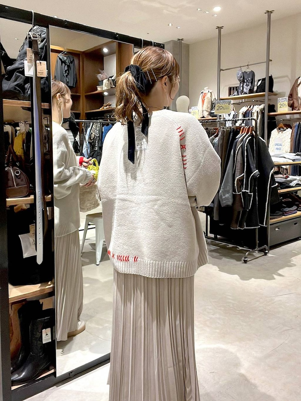 ベージュ系のスカート、ベージュ系のショルダーバッグ、イエロー系のネックレスを着用したレディースの秋コーディネートの6枚目の写真