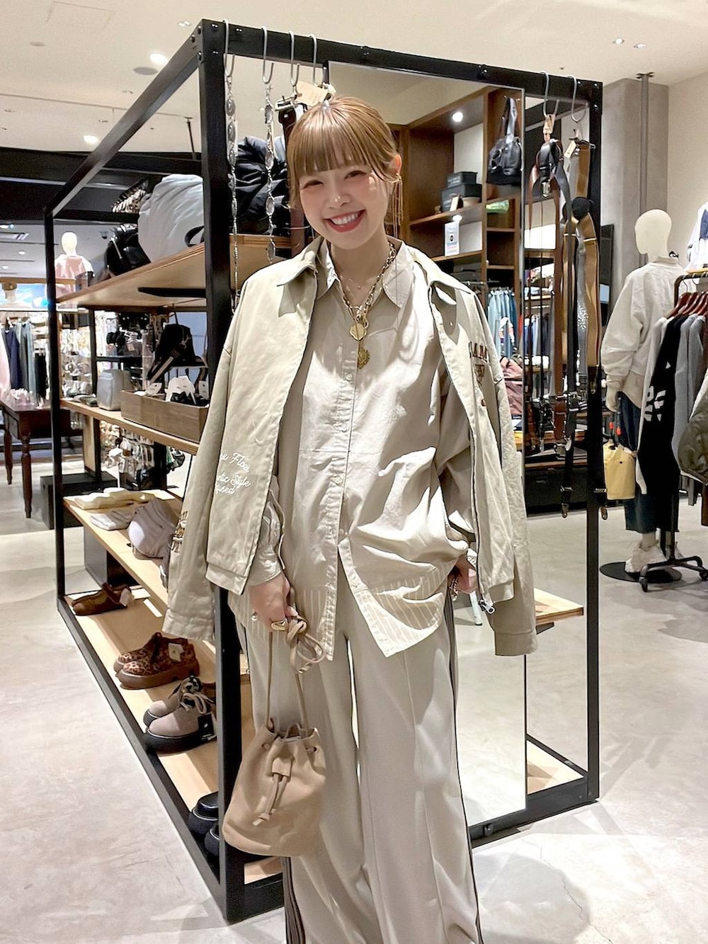 ベージュ系のシャツ/ブラウス、ベージュ系のショルダーバッグ、ベージュ系のスニーカーを着用したレディースの冬コーディネートの6枚目の写真