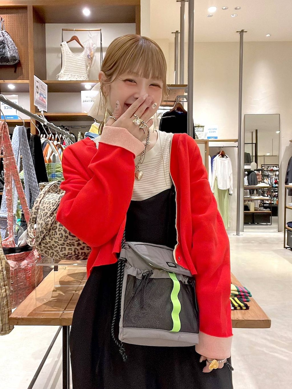 レッド系のカーディガン/ボレロ、ホワイト系のヘアゴムを着用したレディースの春コーディネートの7枚目の写真