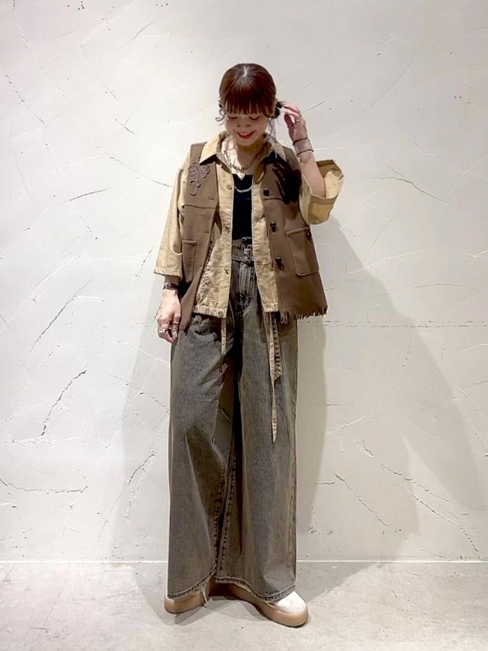 ベージュ系のシャツ/ブラウス、ブラウン系のデニムパンツ、イエロー系のベストを着用したレディースの夏コーディネートの3枚目の写真
