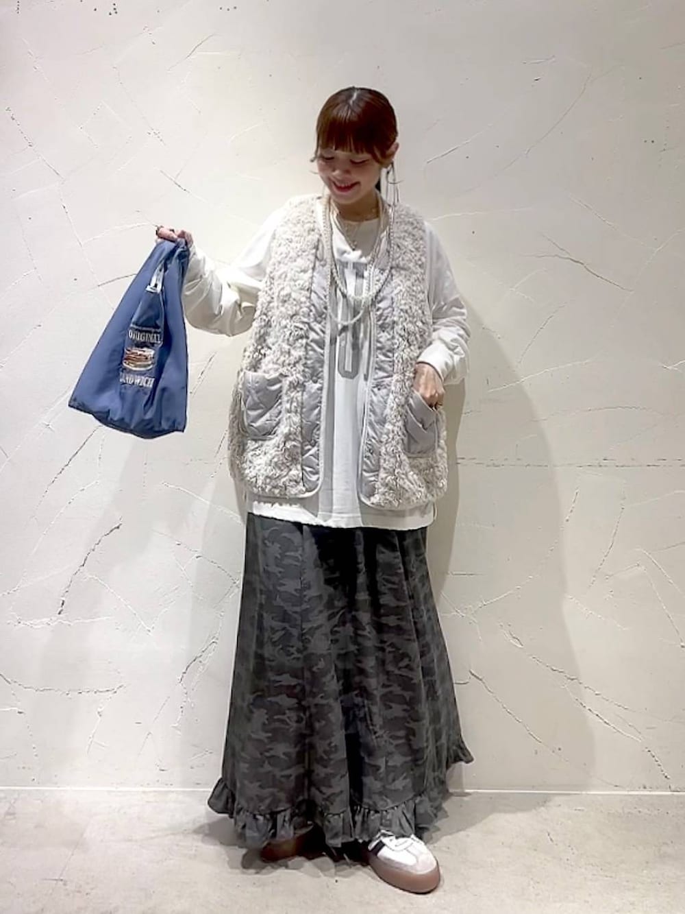 ベージュ系のベスト、その他のトートバッグ、グリーン系のスカートを着用したレディースの秋コーディネートの8枚目の写真