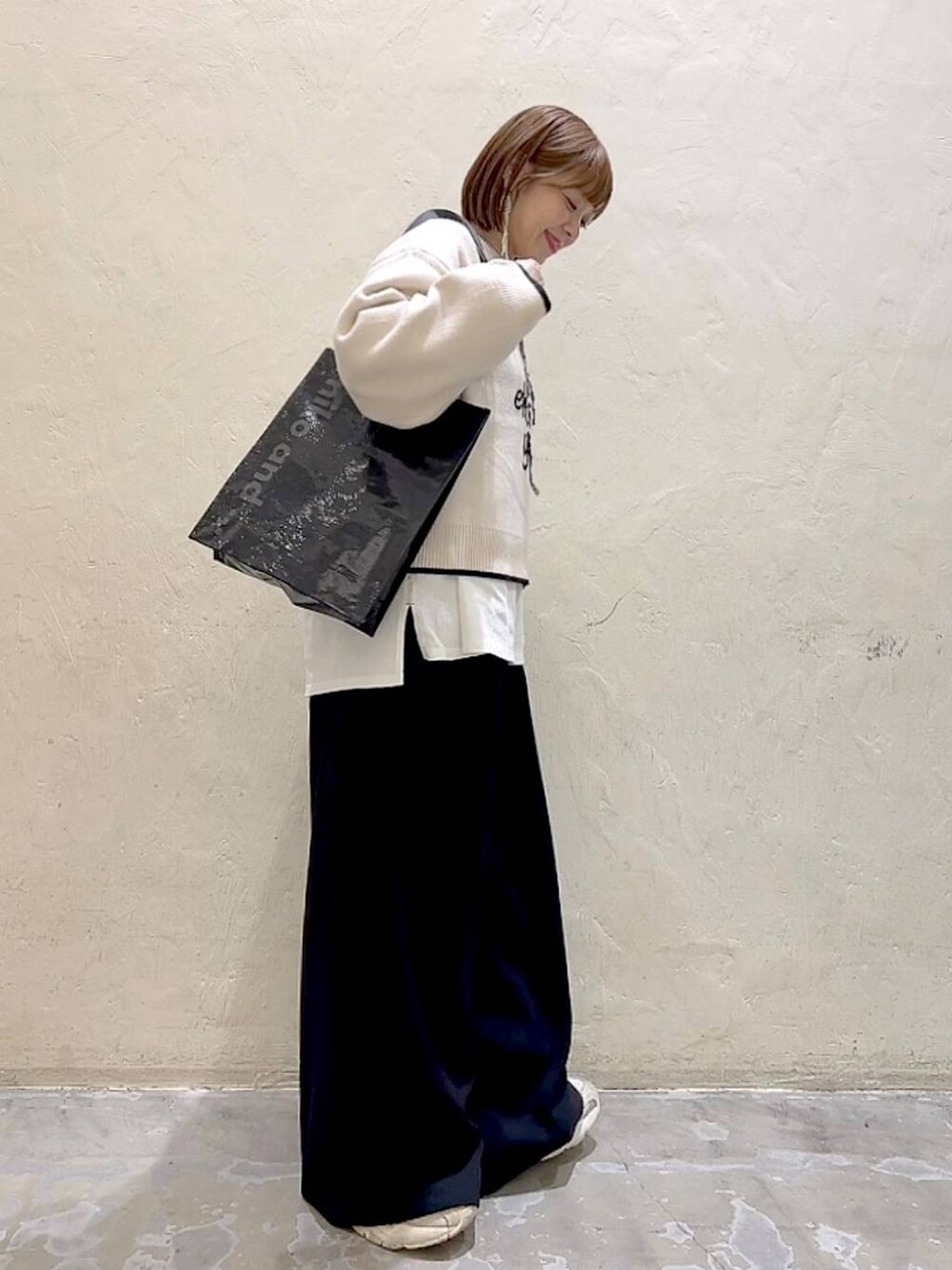 ホワイト系のTシャツ/カットソー、ブラック系のその他パンツ、ベージュ系のニット/セーターを着用したレディースの冬コーディネートの3枚目の写真