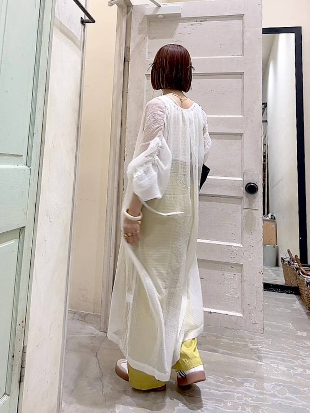 ブルー系のトートバッグ、イエロー系のその他パンツ、ホワイト系のワンピースを着用したレディースの夏コーディネートの4枚目の写真