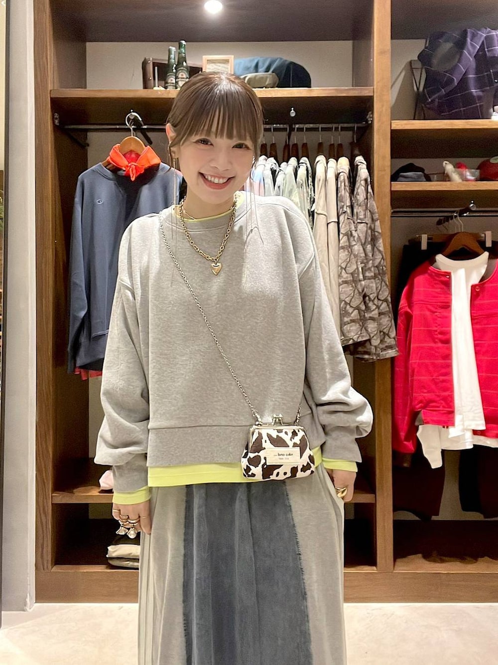 ベージュ系のパンプス、グレー系のスウェット、ブルー系のデニムスカートを着用したレディースの秋コーディネートの2枚目の写真