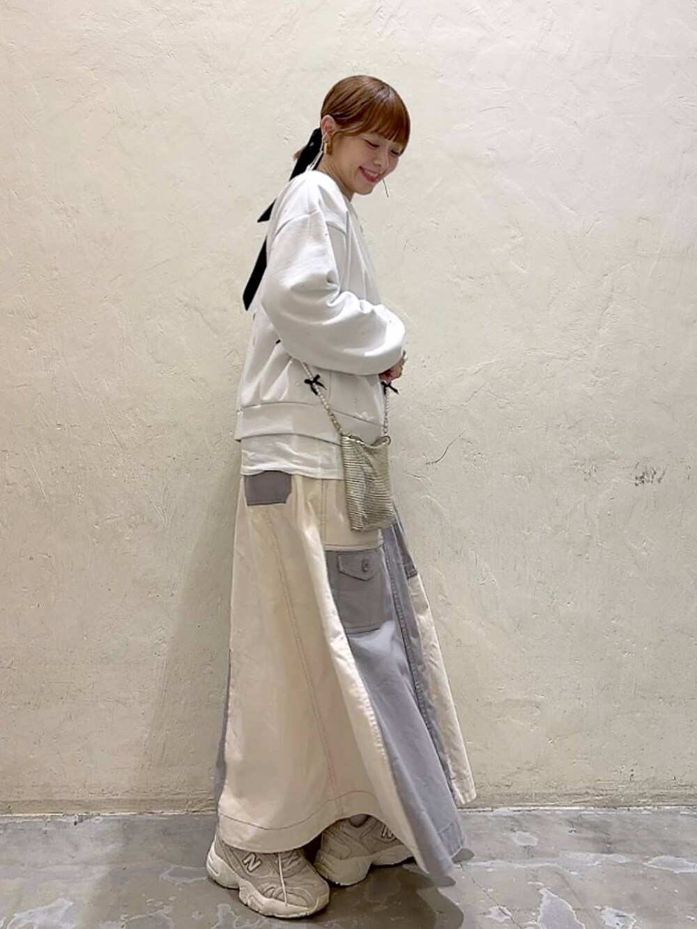 ゴールド系のショルダーバッグ、ホワイト系のTシャツ/カットソー、ホワイト系のその他トップスを着用したレディースの冬コーディネートの4枚目の写真