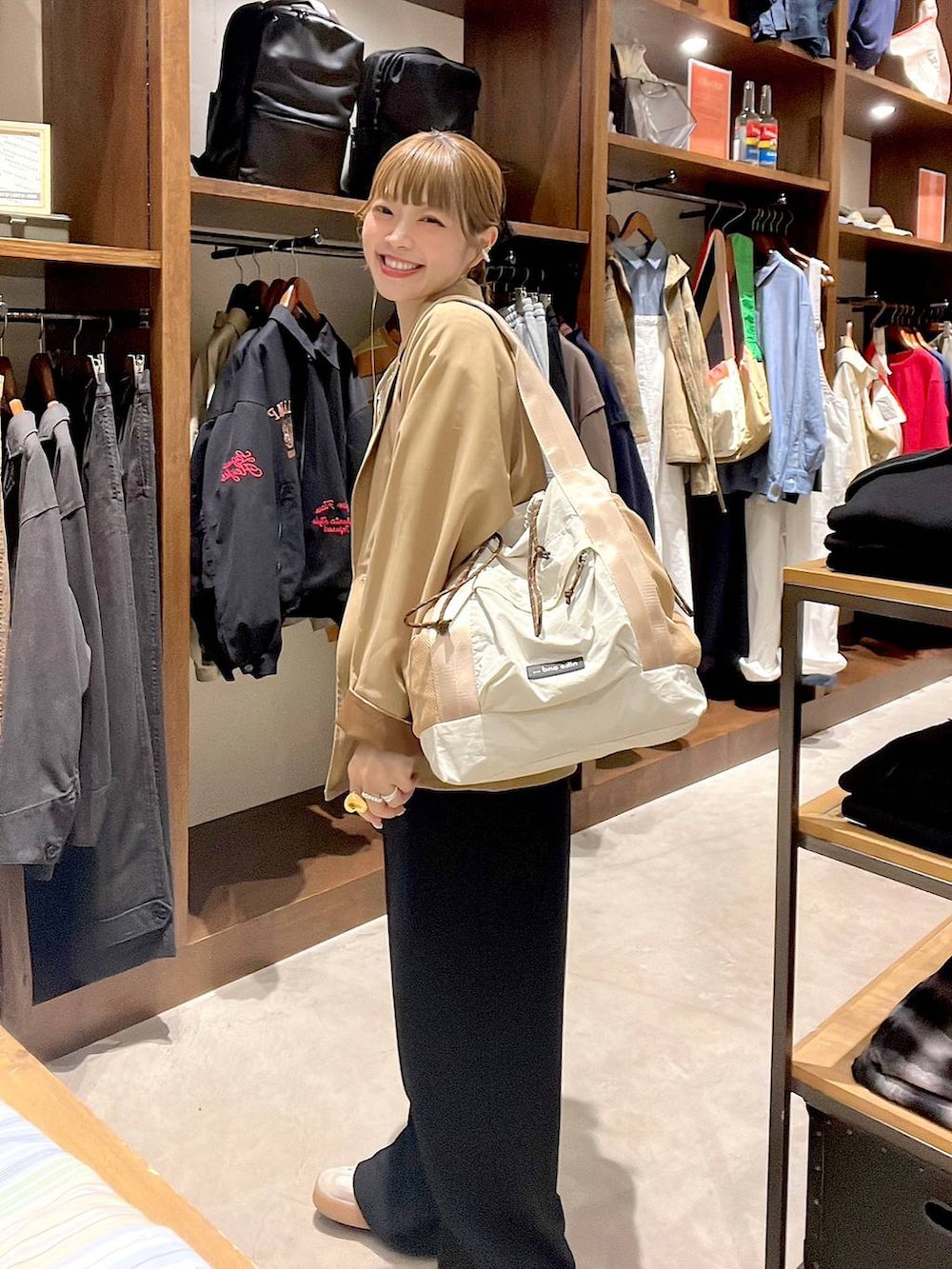 ベージュ系のトートバッグ、ブラック系のサロペット/オーバーオール、ホワイト系のTシャツ/カットソーを着用したレディースの冬コーディネートの6枚目の写真