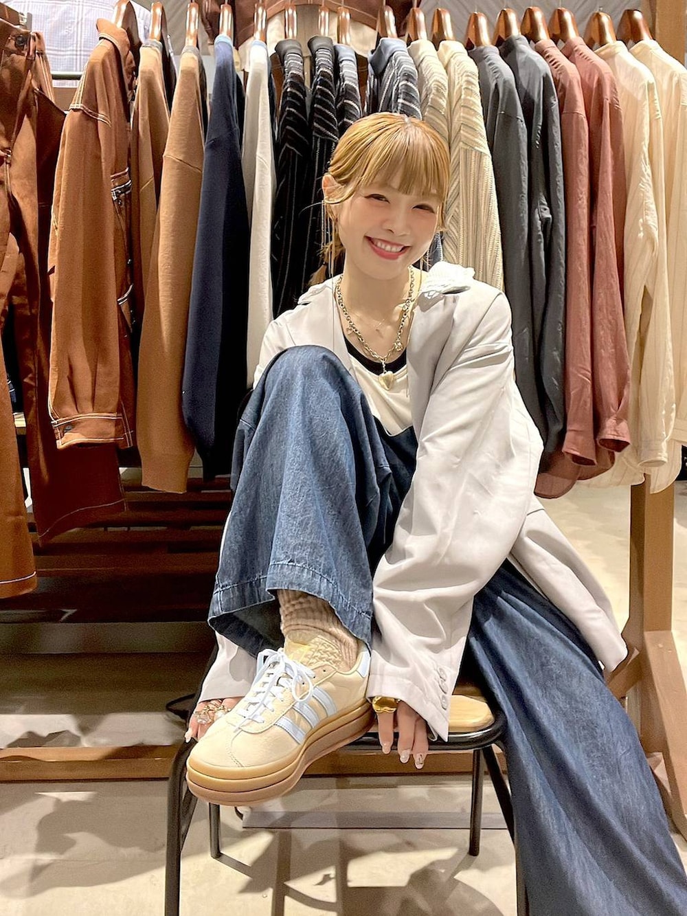 ベージュ系のスニーカー、グレー系のテーラードジャケット、ホワイト系のタンクトップを着用したレディースの春コーディネートの5枚目の写真