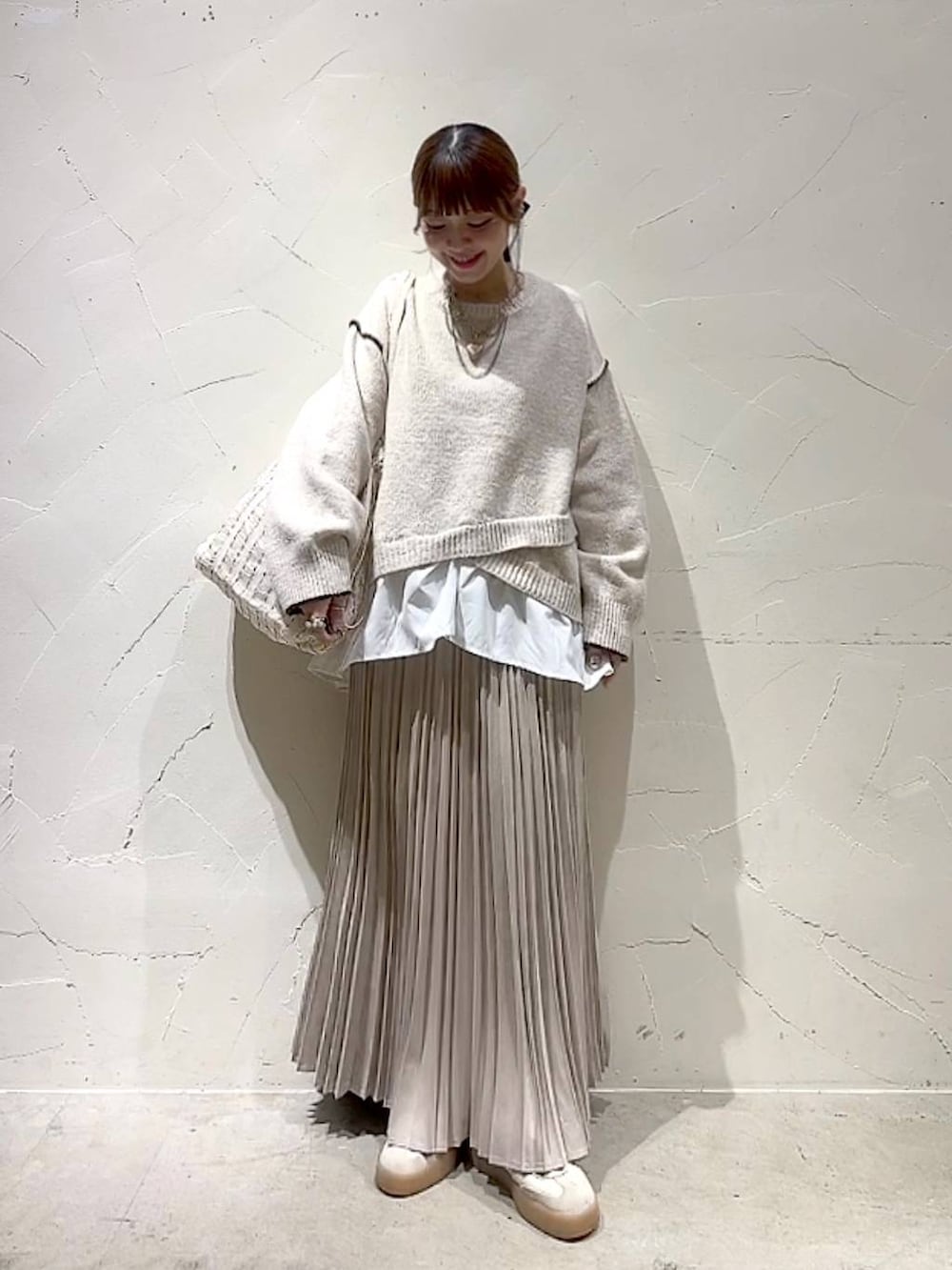 ベージュ系のスカート、その他のトートバッグ、ゴールド系のネックレスを着用したレディースの秋コーディネートの8枚目の写真