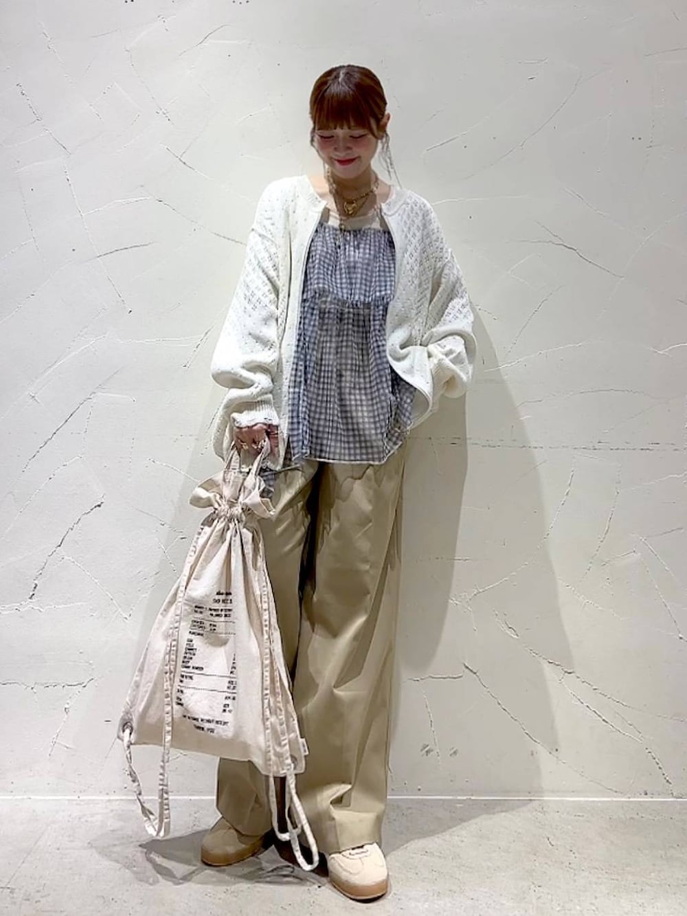 ベージュ系のチノパンツ、ホワイト系のブルゾン、ホワイト系のキャミソールを着用したレディースの春コーディネートの7枚目の写真