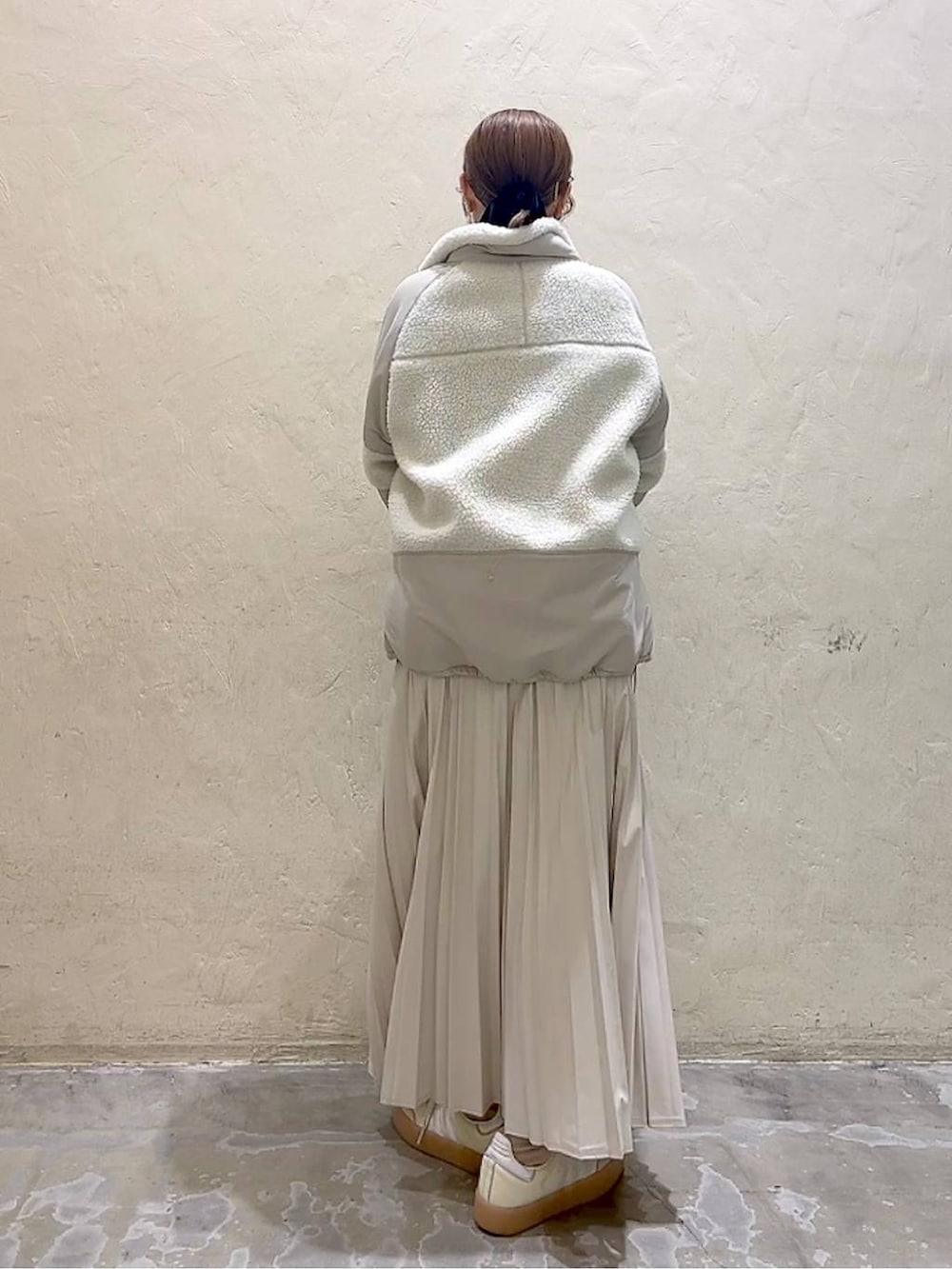 ベージュ系のスカート、ベージュ系のブルゾン、グレー系のニット/セーターを着用したレディースの秋コーディネートの4枚目の写真