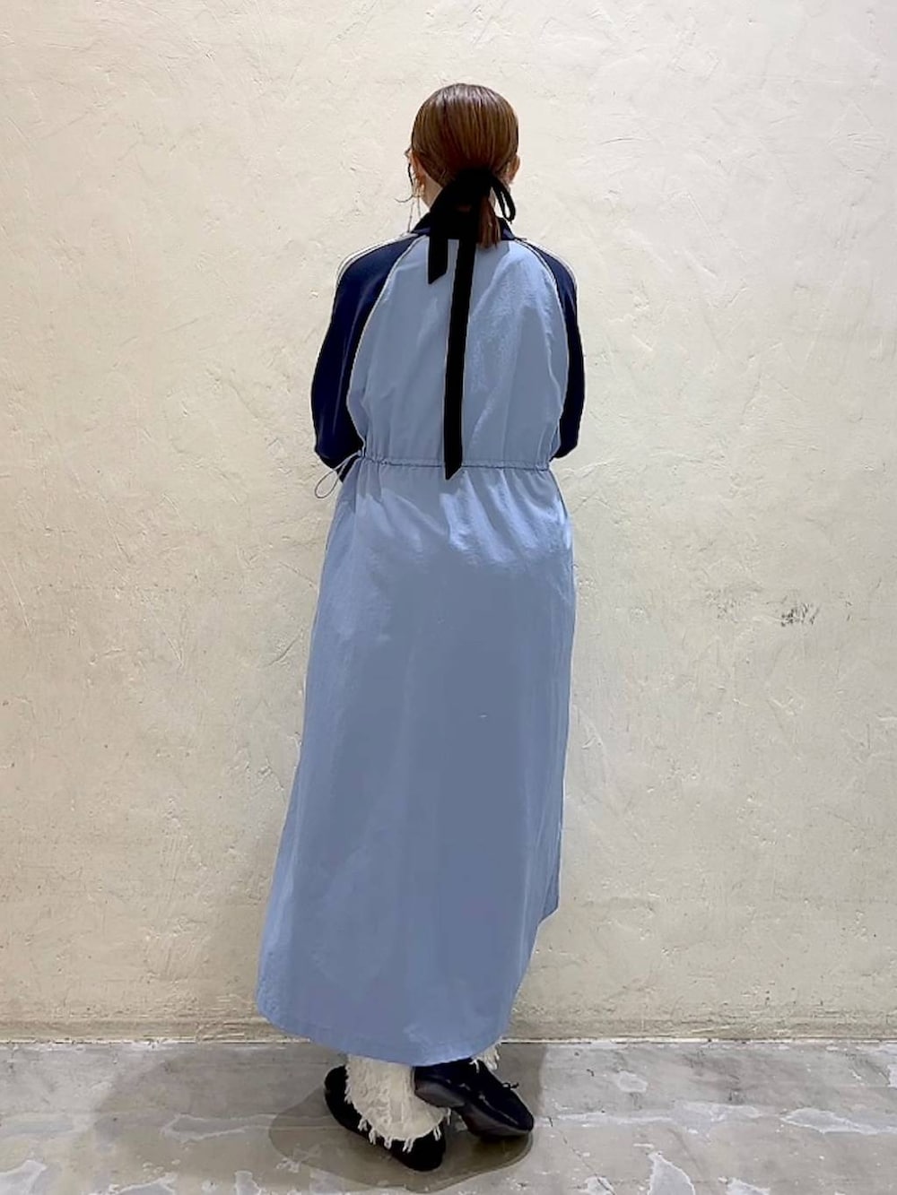 ブルー系のワンピース、ブラック系のパンプス、ブラック系のキャミソールを着用したレディースの冬コーディネートの5枚目の写真