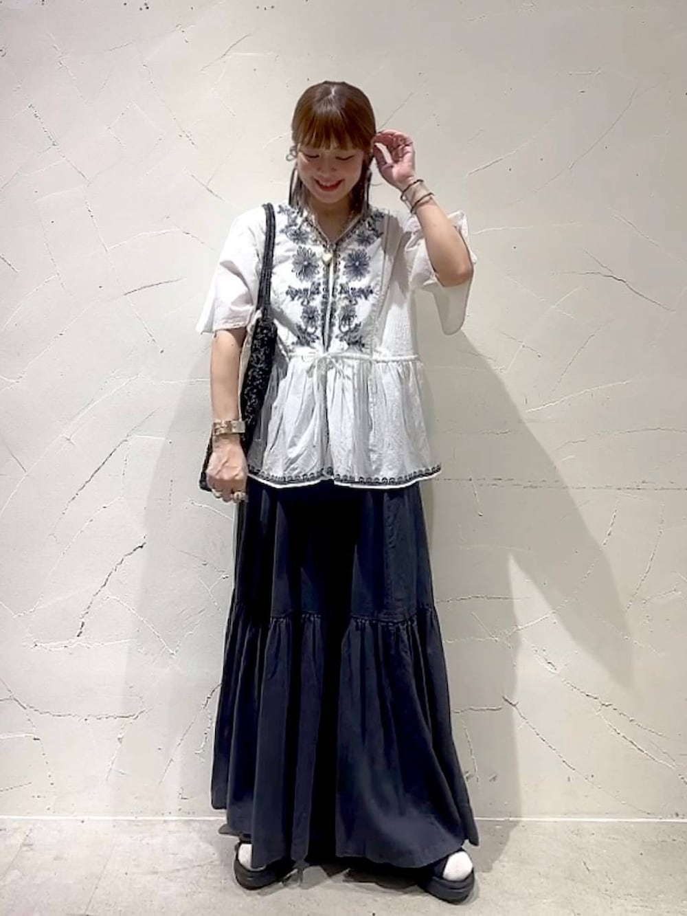 グレー系のスカート、ホワイト系のシャツ/ブラウス、ブラック系のトートバッグを着用したレディースの春コーディネートの8枚目の写真