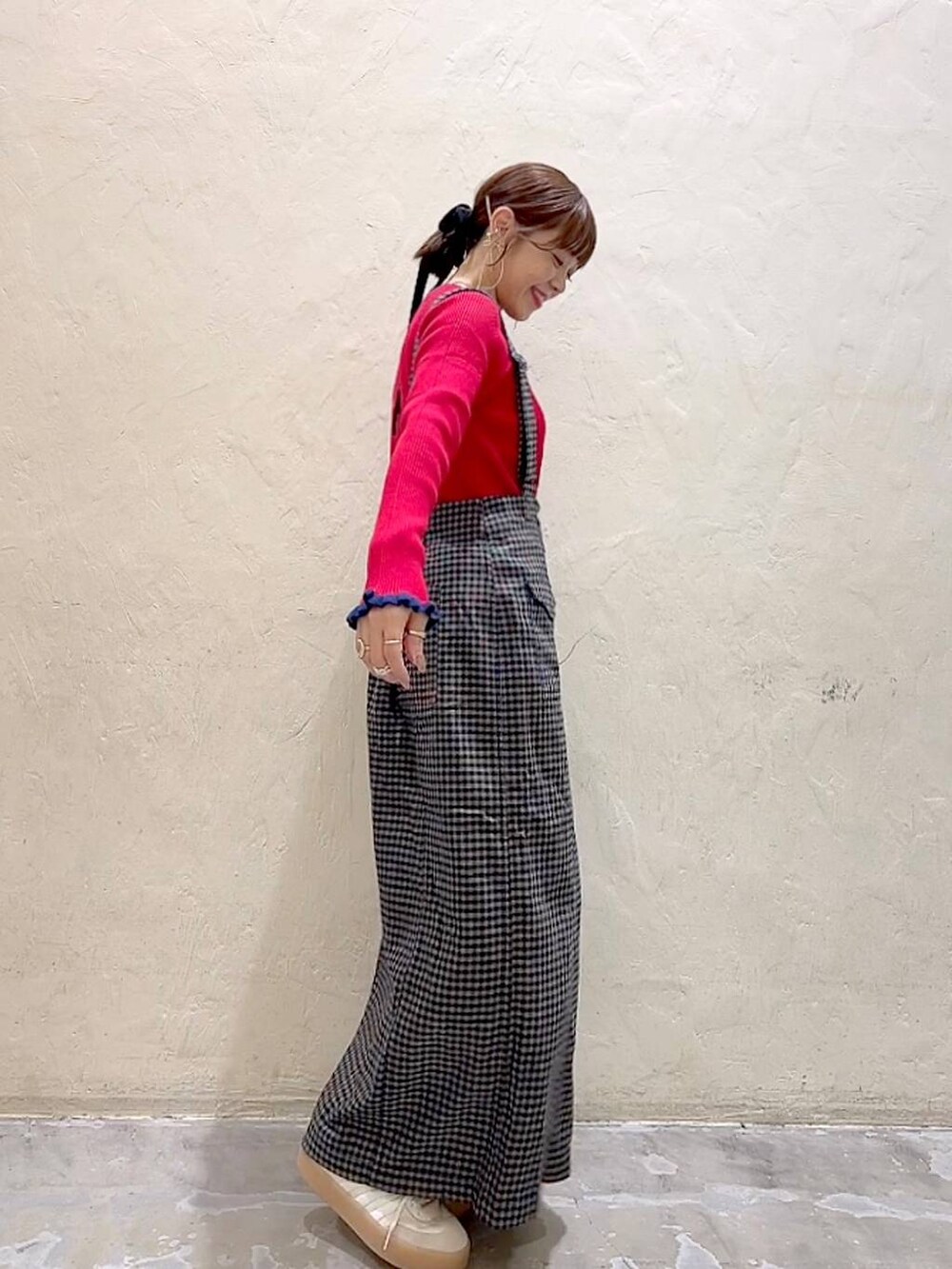 ブラック系のスカート、レッド系のニット/セーターを着用したレディースの秋コーディネートの4枚目の写真