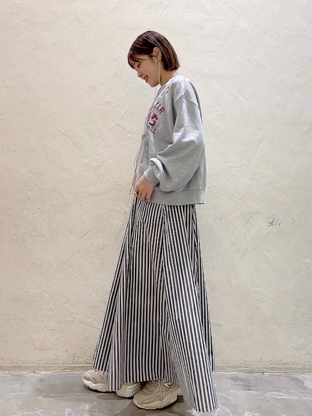グレー系のTシャツ/カットソー、ブルー系のスカートを着用したレディースの春コーディネートの5枚目の写真