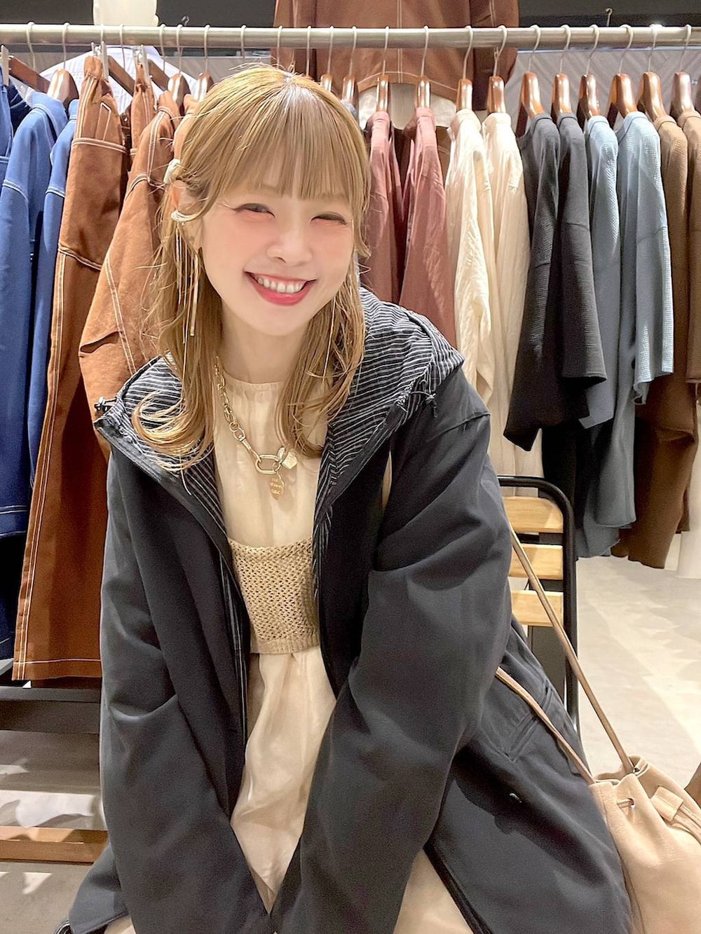 ベージュ系のデニムパンツ、ベージュ系のショルダーバッグ、グレー系のその他アウターを着用したレディースの春コーディネートの4枚目の写真