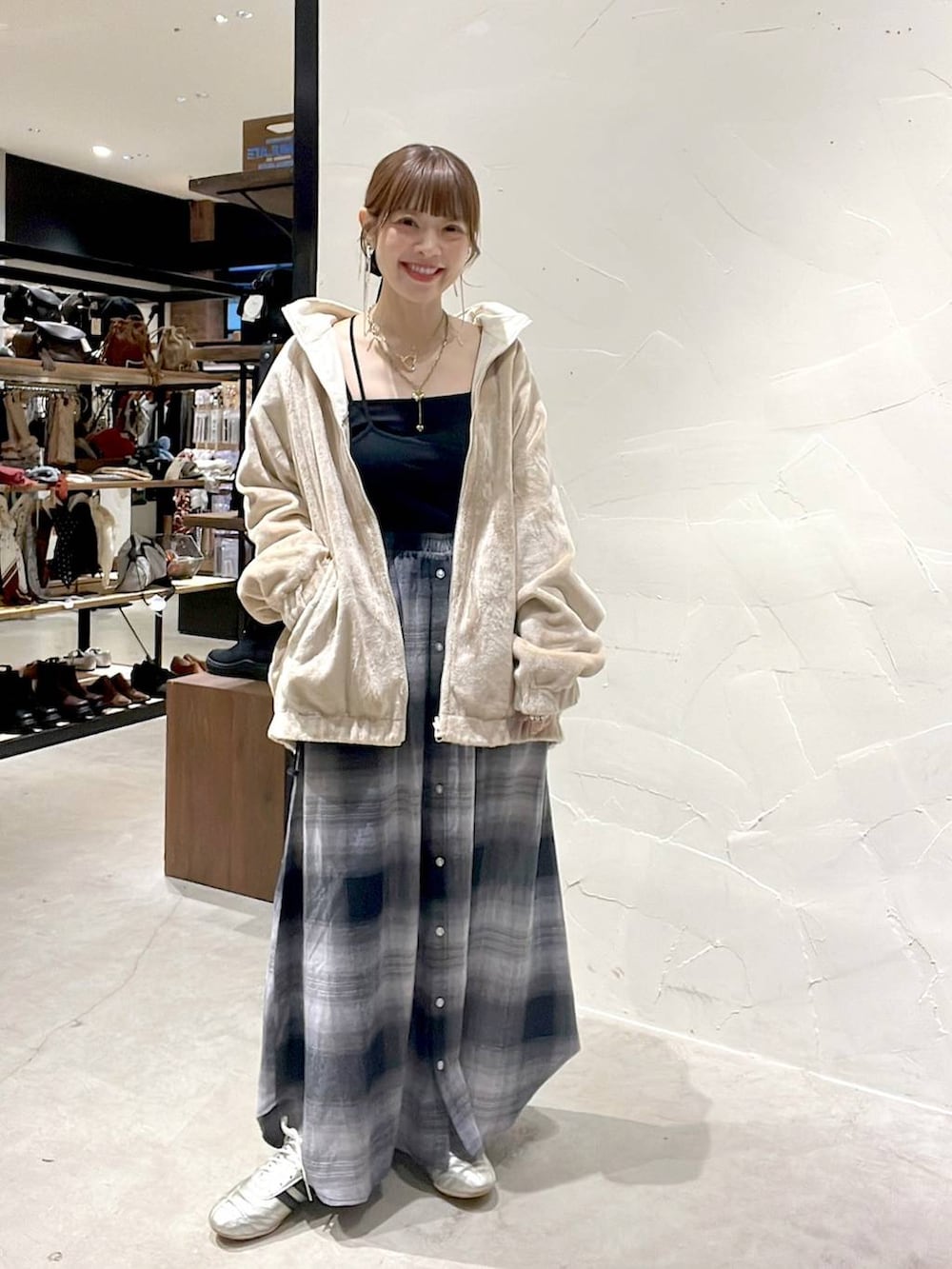 ゴールド系のスニーカー、ベージュ系のブルゾン、イエロー系のネックレスを着用したレディースの秋コーディネートの2枚目の写真