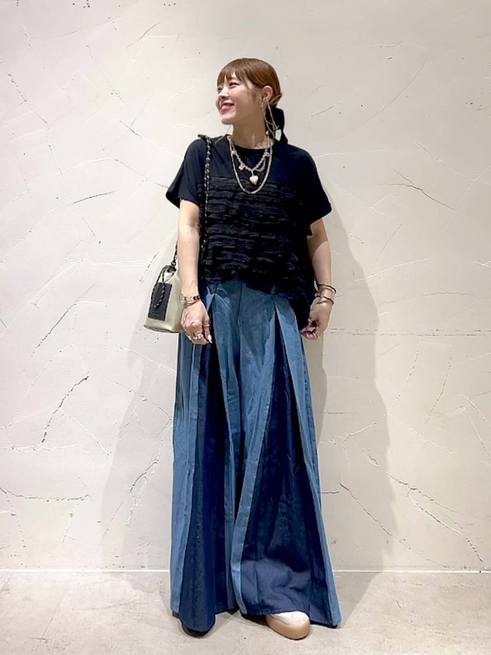 グレー系のショルダーバッグ、ブラック系のTシャツ/カットソー、ゴールド系のネックレスを着用したレディースの秋コーディネートの8枚目の写真