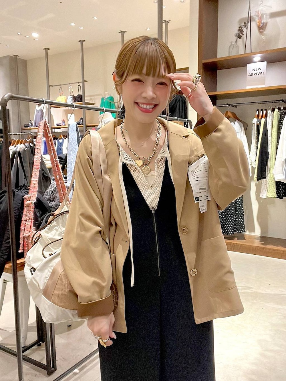 ベージュ系のトートバッグ、ブラック系のサロペット/オーバーオール、ホワイト系のTシャツ/カットソーを着用したレディースの冬コーディネートの2枚目の写真