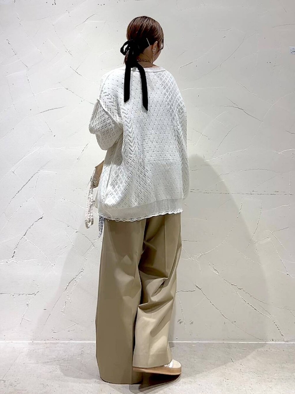 ベージュ系のチノパンツ、ホワイト系のブルゾン、ホワイト系のキャミソールを着用したレディースの春コーディネートの5枚目の写真