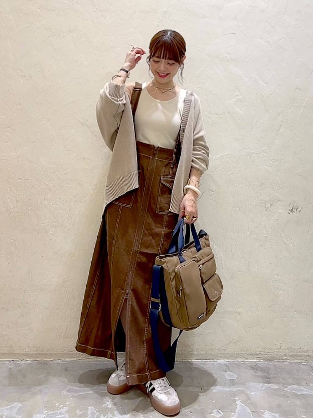 ベージュ系のカーディガン/ボレロ、ブラウン系のスカート、ブラウン系のトートバッグを着用したレディースの秋コーディネートの7枚目の写真